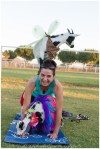 girl on knees with goat on her back